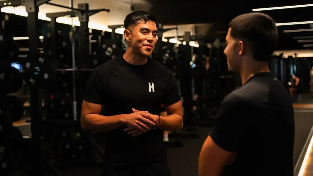 Housed personal trainer talking through a client’s training progress in the gym