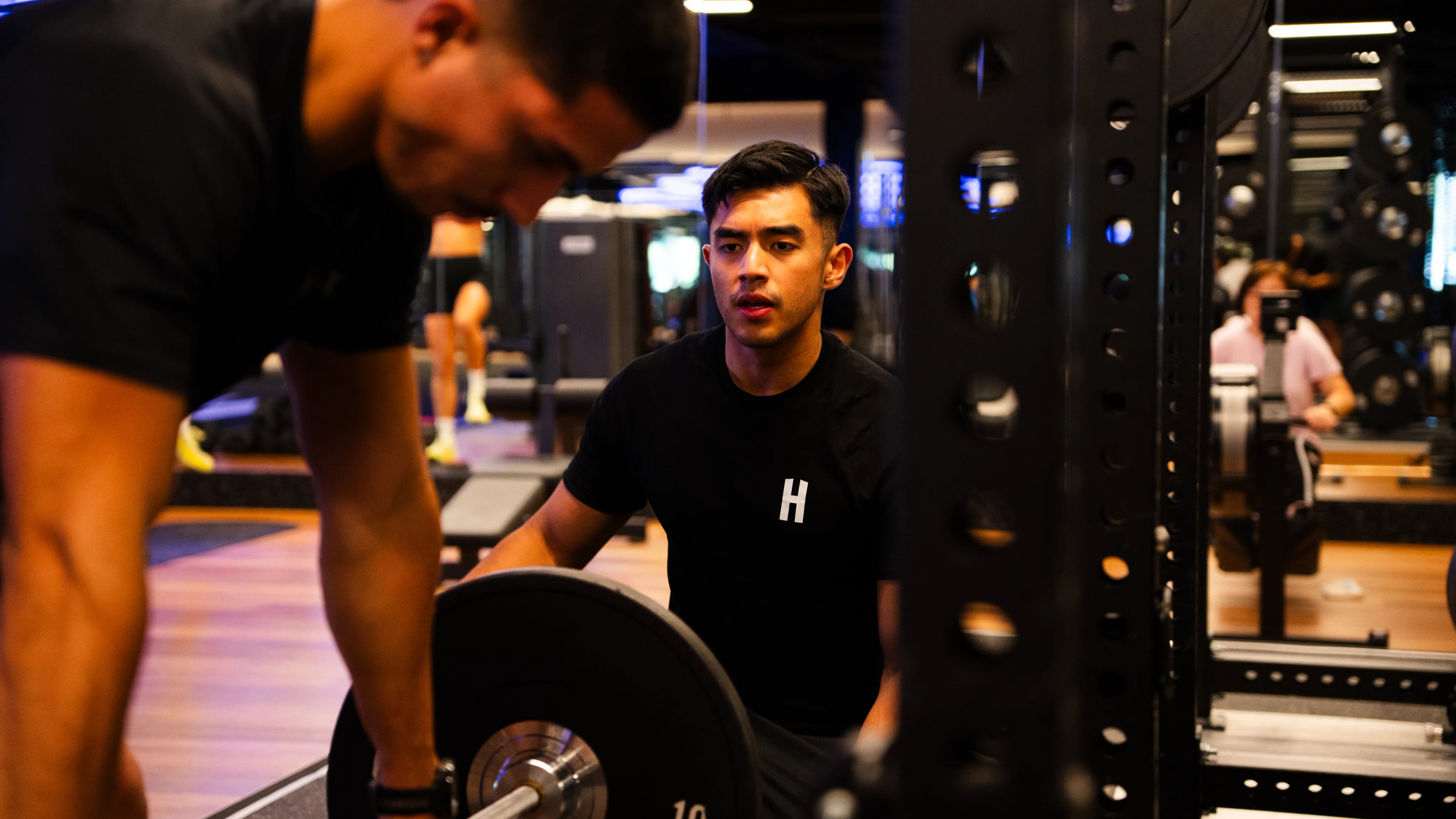 Housed expert coaches with a client on the gym floor