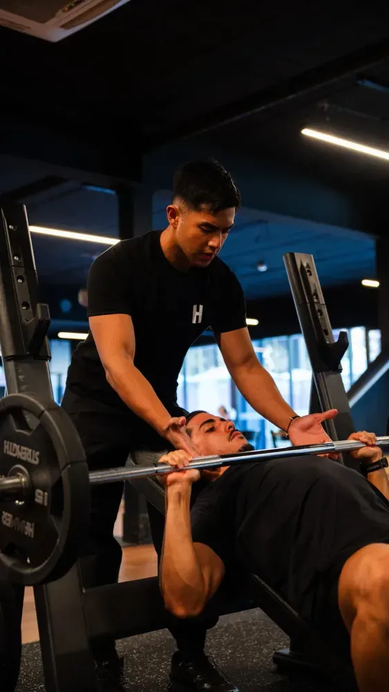 Housed coach guiding a client through a strength training session
