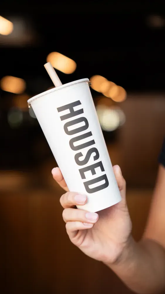 Person holding a Housed water bottle, representing nutrition guidance for training