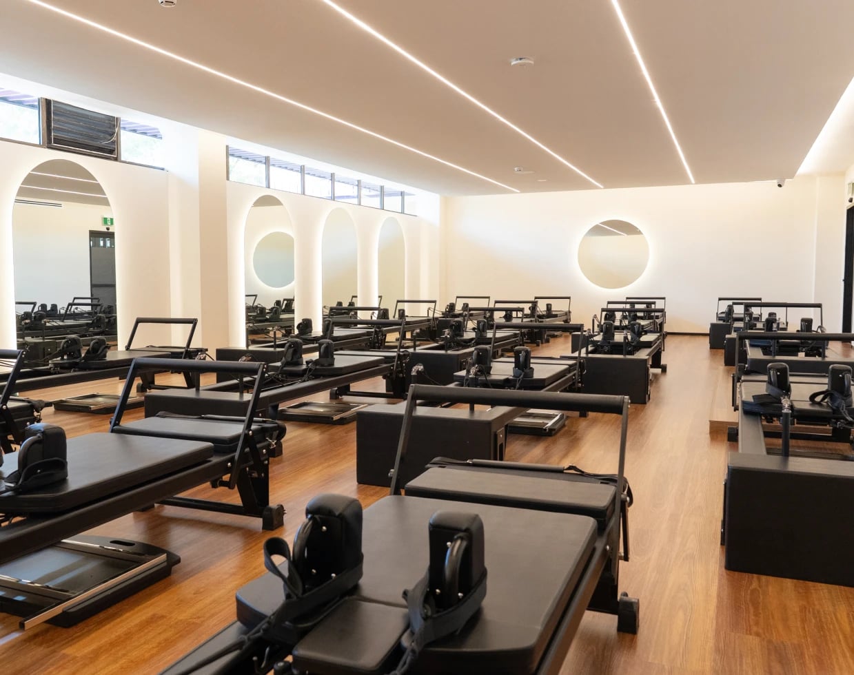 Housed Pilates reformer studio with modern equipment and dedicated teacher stage
