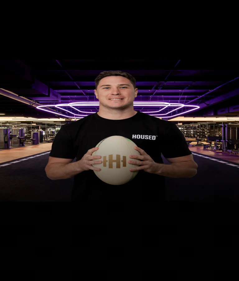 Housed Macquarie Park fitness club interior with modern gym equipment, purple LED lighting, and professional trainer demonstrating equipment