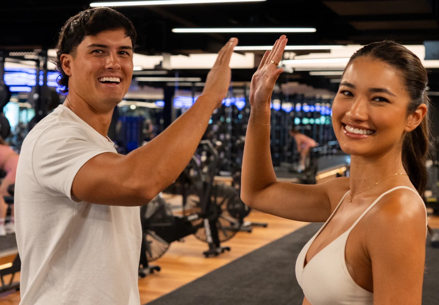 Two friends celebrating with a high five at Housed Fitness gym in Sydney